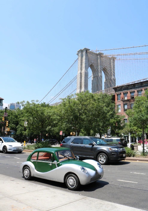 Model O1 on a Brooklyn street with the Brooklyn Bridge behind it